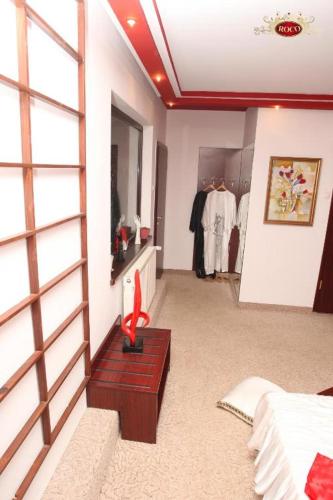 a room with a dressing room with a bed and a dressing table at Hotel Roco in Izvin