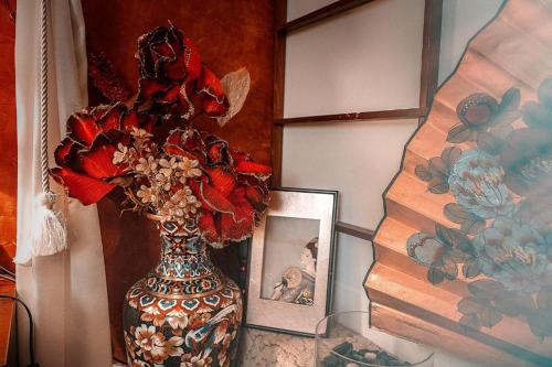 a vase with flowers in it next to a picture at Hotel Roco in Izvin