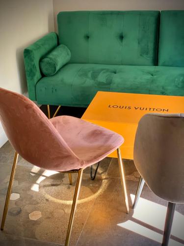a living room with a green couch and a chair at Santafe' in Vietri sul Mare