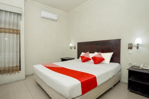 - une chambre dotée d'un grand lit avec des oreillers rouges et blancs dans l'établissement OYO 1005 Hotel Kumala, à Samarinda