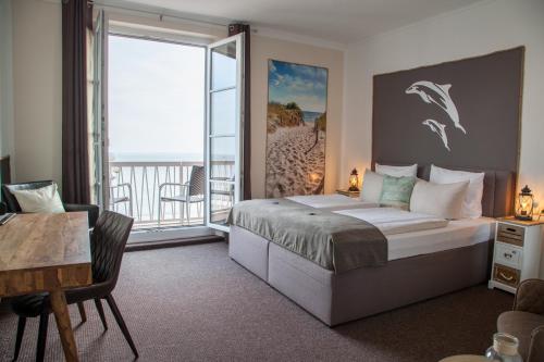 a bedroom with a large bed and a balcony at AKZENT Strandhotels Seestern, Delphin & Lachs in Wilhelmshaven