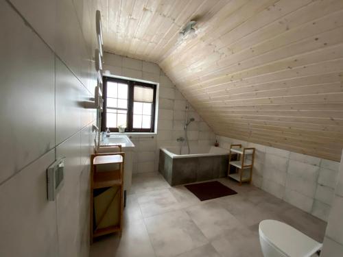 a bathroom with a sink and a bath tub at Górskie Formy - drewniany dom w górach z balią in Leszczyniec