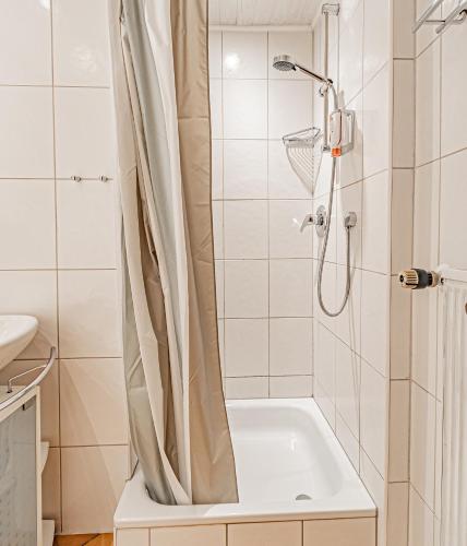 a bathroom with a shower with a bath tub at Johannishof Wein-Café & Gästehaus in Mesenich