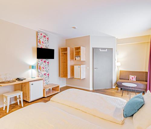 a bedroom with a large bed and a desk at Johannishof Wein-Café & Gästehaus in Mesenich