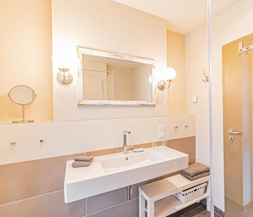 a bathroom with a white sink and a mirror at Johannishof Wein-Café & Gästehaus in Mesenich