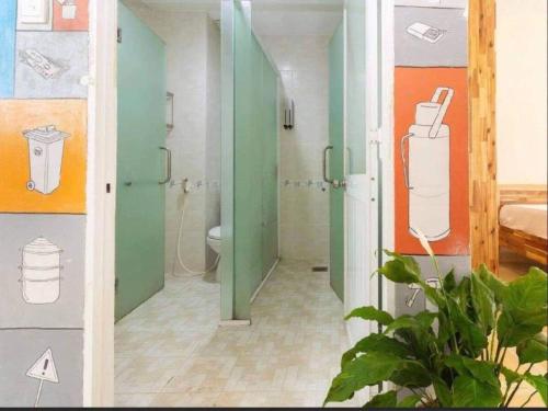 ein Badezimmer mit grünen und orangefarbenen Wänden und einem WC in der Unterkunft SaiGon Gạo Hostel in Ho-Chi-Minh-Stadt