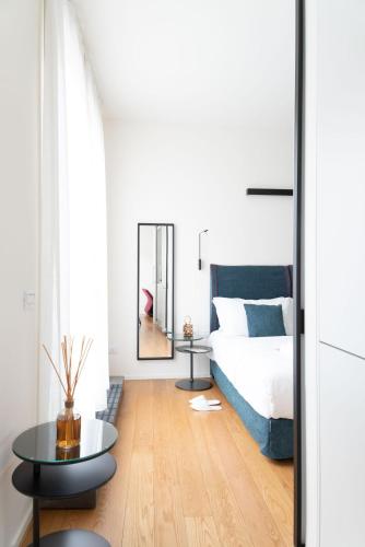 a bedroom with a bed and a table and a mirror at BMORE Duomo - Luxury Apartments near Duomo in Milan