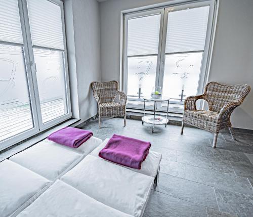 two beds in a room with two chairs and a table at Johannishof Wein-Café & Gästehaus in Mesenich