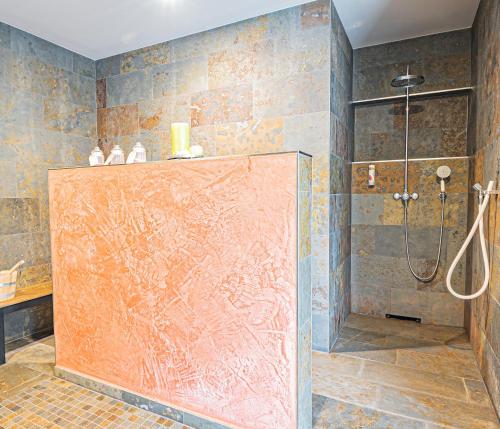 a bathroom with a shower with a glass door at Johannishof Wein-Café & Gästehaus in Mesenich