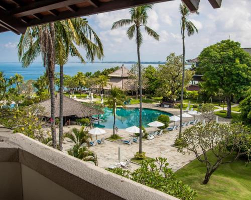 a view of the pool and beach from the balcony of a resort at Discovery Kartika Plaza Hotel in Kuta