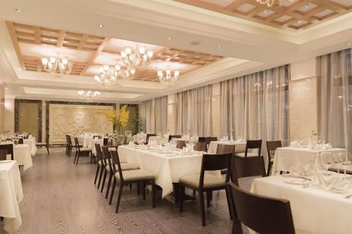 a dining room with white tables and chairs and chandeliers at Golden Tulip Addis Ababa in Addis Ababa