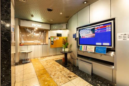 a room with a large tv in a building at Hotel Liberty Kochi (Adult Only) in Kochi