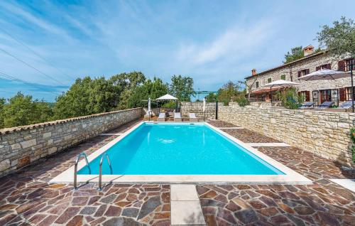 una piscina en una pared de piedra junto a una casa en Villa Kluni, en Momjan