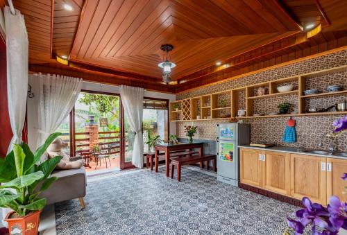 Il comprend une cuisine dotée de plafonds en bois et une salle à manger. dans l'établissement Art Villa Hoi An, à Hội An