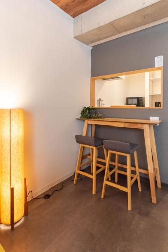 a kitchen with a table and stools in a room at Alla Scuderia Bijou Suites in Osaka