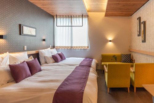 a hotel room with a large bed and a desk at Alla Scuderia Bijou Suites in Osaka