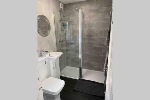 a bathroom with a shower and a toilet and a sink at On The Harbour - unrivalled views of Amble's harbour and estuary in Amble