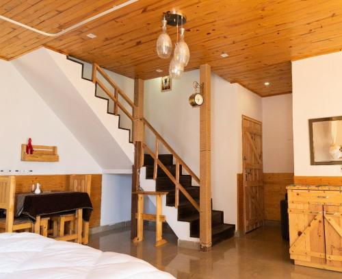- une chambre avec un escalier, une table et un lit dans l'établissement The Naturewalk, à Mukteswar