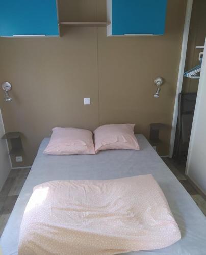 a bed in a room with pink pillows on it at Mobile Homes by KelAir at Playa Montroig Camping Resort in Tarragona