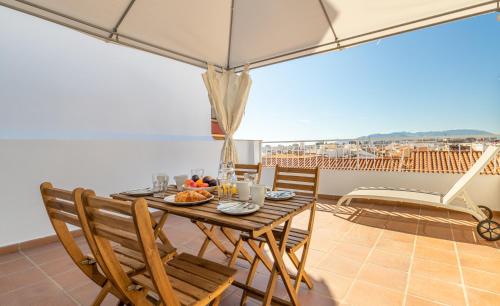 a dining room with a table and chairs on a balcony at HOMEABOUT LA MERCED Duplexes in Málaga