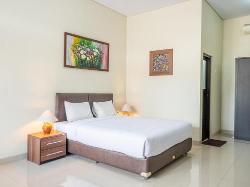 1 dormitorio con 1 cama y una foto en la pared en Hotel Parahyangan, en Tasikmalaya
