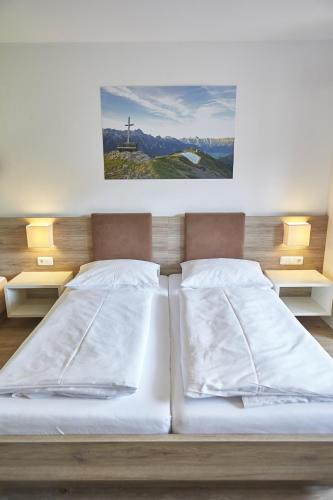 a bedroom with two beds and a picture on the wall at Am Mitteregghof in Saalbach Hinterglemm