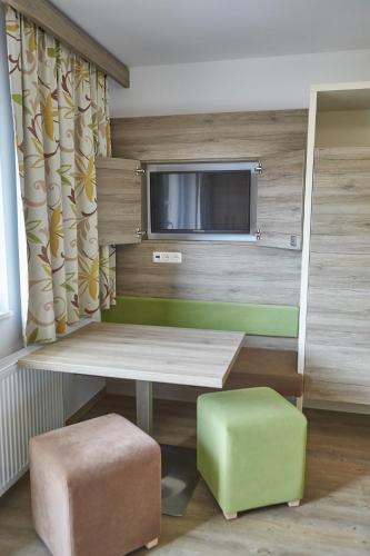 a room with a table and two stools and a television at Am Mitteregghof in Saalbach Hinterglemm