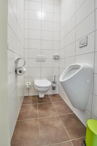 a bathroom with a toilet and a urinal and a sink at Am Mitteregghof in Saalbach Hinterglemm