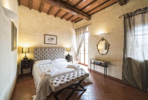 a bedroom with a bed and a large window at Fattoria Casagrande in Rignano sullʼArno