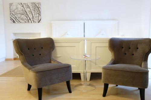 two chairs and a glass table in a room at Parkhotel Sole Paradiso in San Candido