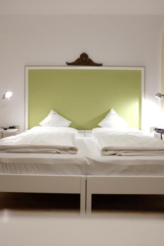 a large white bed with a large mirror above it at Parkhotel Sole Paradiso in San Candido