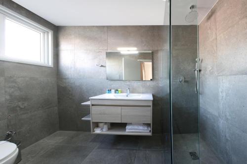 La salle de bains est pourvue d'un lavabo et d'une douche en verre. dans l'établissement Centrum Hotel - City Center, à Nicosie