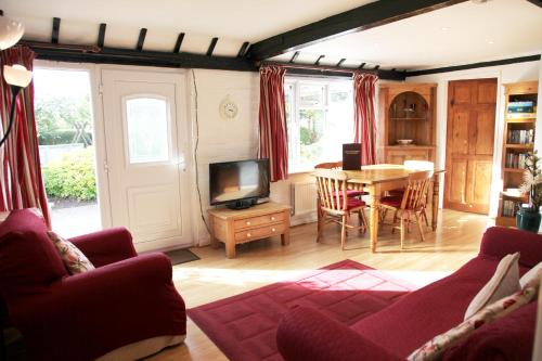 uma sala de estar com uma mesa e uma televisão em Sheephouse Manor em Maidenhead