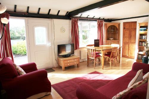 sala de estar con mesa y TV en Sheephouse Manor, en Maidenhead