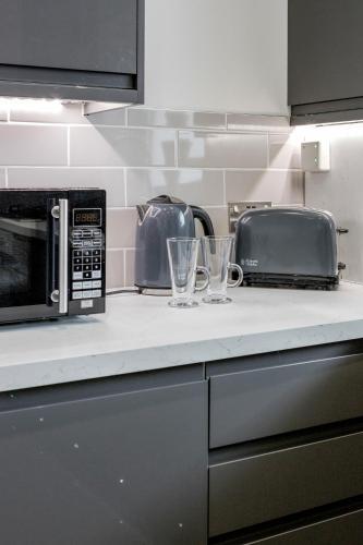 a kitchen counter with a microwave and a toaster at Luxury Chic Apartment near Canary Wharf, Excel, O2 & Stratford in London