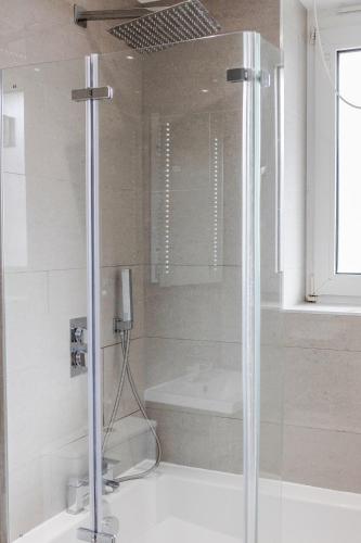 a shower in a bathroom with a bath tub and a shower at Luxury Chic Apartment near Canary Wharf, Excel, O2 & Stratford in London