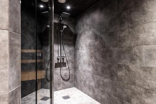 La salle de bains est pourvue d'une douche avec une porte en verre. dans l'établissement RukaValley Unique58, à Ruka