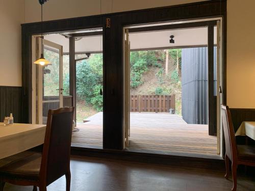 a dining room with a sliding door to a deck at Matsushima Petit Hotel Bistro Abalon in Matsushima