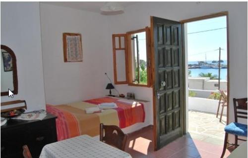 a bedroom with a bed and a door leading to a patio at Eleni's Studios in Karavostasi