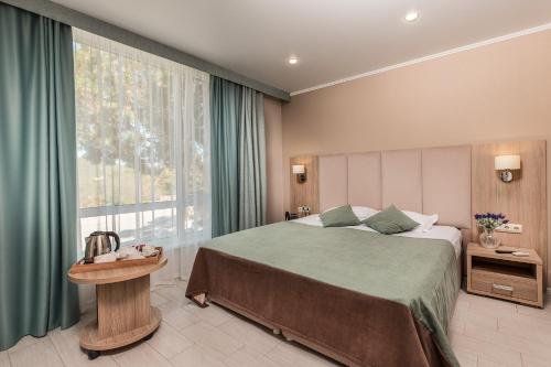 a bedroom with a large bed and a large window at Elka Hills Hotel in Sukko