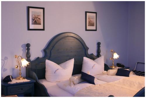 a bedroom with two beds with white pillows at Landhaus Krabbe von Greetsiel in Greetsiel