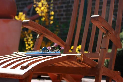 a pair of glasses and a book on a wooden chair at Landhaus Krabbe von Greetsiel in Greetsiel