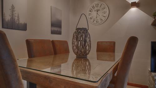 a dining room with a glass table and a clock at Saplan Real Estate PORTET in Les
