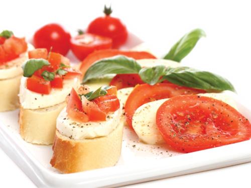 a plate of food with sandwiches and tomatoes on it at Invito Guesthouse in Sihanoukville