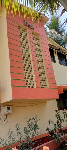 a building with red stripes on the side of it at HemHarsh Holiday Home with pool in Karjat