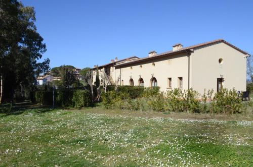 un antiguo edificio en un campo de flores en Il Poggio di San Ruffino, en Lari