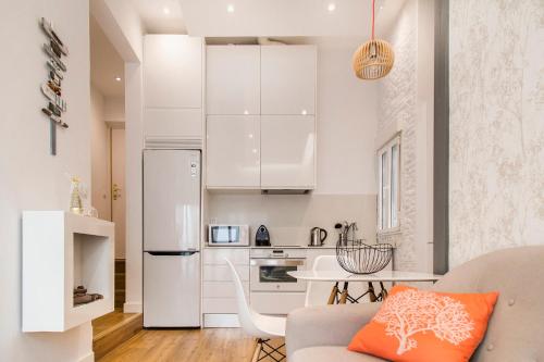 cocina con nevera blanca y mesa en Modern apartment, self check-in, Wi-Fi, Smart TV 55" 4K, en Madrid