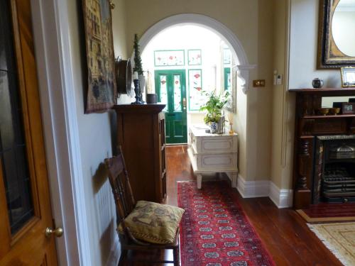 a hallway with an archway and a chair and a door at Lakeside Bed & Breakfast in Perth