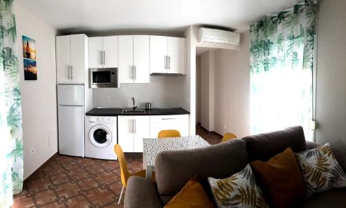 a living room with a couch and a kitchen at Apartamentos MareaBeach in Torremolinos
