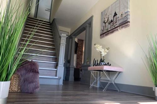 a hallway with a staircase and a table with flowers at Centrally Located 5BR house in Niagara Falls in Niagara Falls